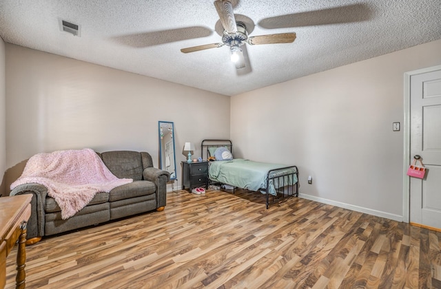 bedroom featuring ceiling fan, a textured ceiling, and light wood-type flooring