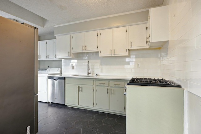 kitchen featuring washer and dryer, sink, backsplash, dishwasher, and range with gas cooktop