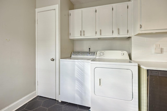 clothes washing area with washer and dryer and dark tile patterned floors