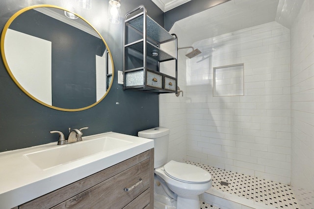 bathroom with toilet, vanity, and tiled shower