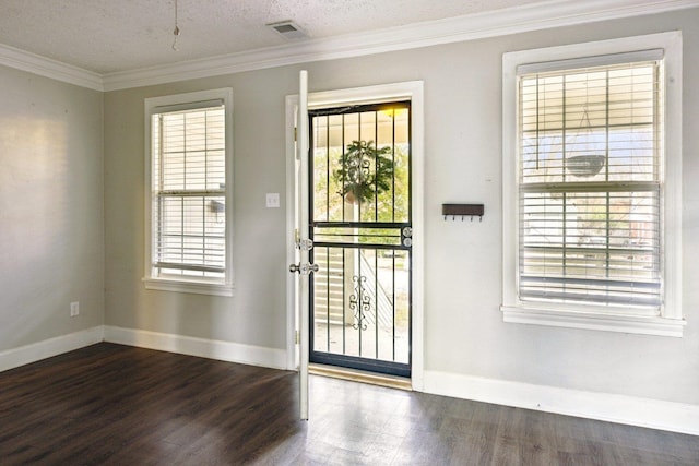 foyer entrance with a textured ceiling, dark wood-type flooring, and ornamental molding