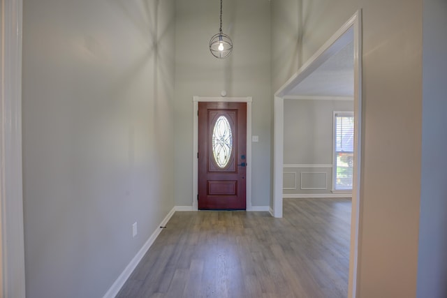 foyer featuring crown molding and wood-type flooring