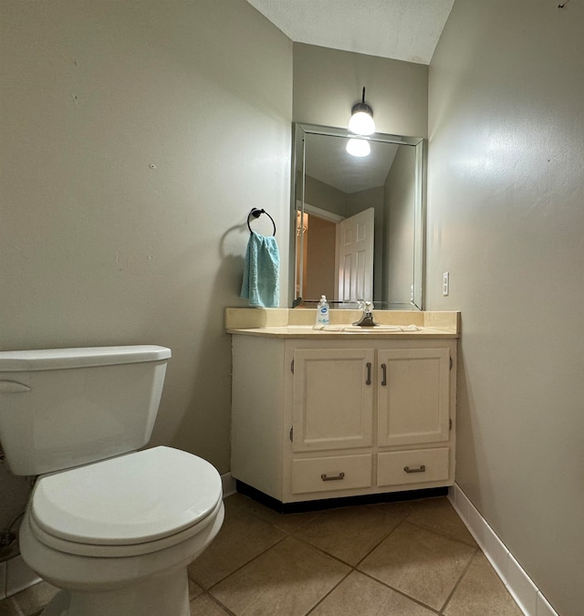 bathroom featuring tile patterned flooring, vanity, and toilet