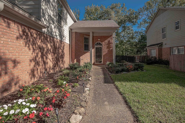 view of exterior entry with a lawn