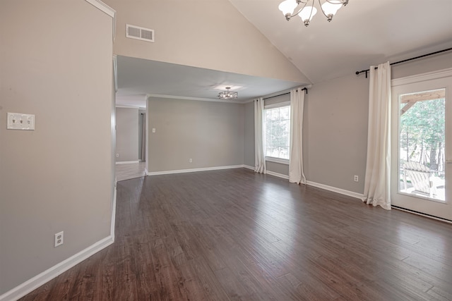 unfurnished room with a wealth of natural light, high vaulted ceiling, dark wood-type flooring, and an inviting chandelier