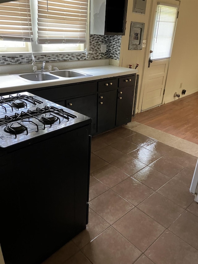 kitchen featuring a healthy amount of sunlight, tile patterned flooring, and black gas stove