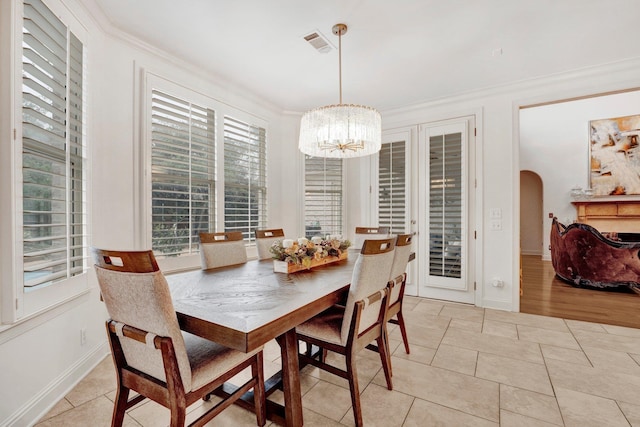 dining area featuring light tile patterned floors, an inviting chandelier, and ornamental molding