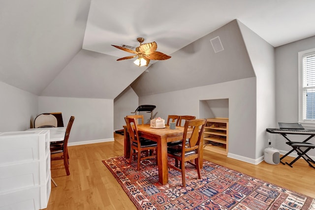 dining area with hardwood / wood-style floors, ceiling fan, and vaulted ceiling