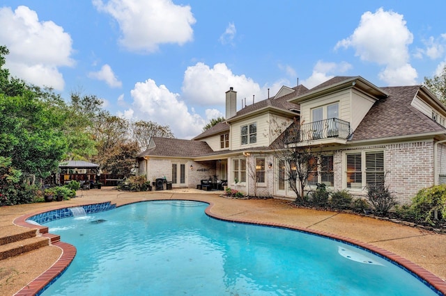 view of pool with pool water feature and a patio