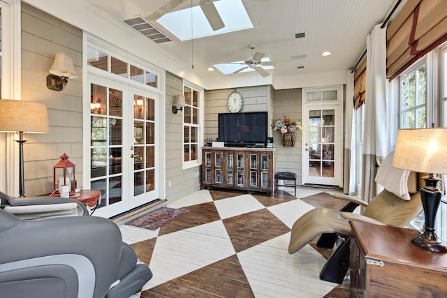 living room featuring french doors, a skylight, light hardwood / wood-style flooring, and ceiling fan