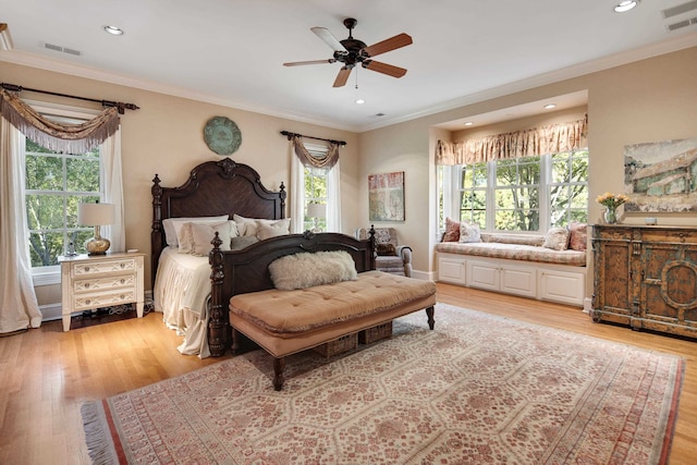 bedroom featuring ceiling fan, ornamental molding, and light hardwood / wood-style flooring