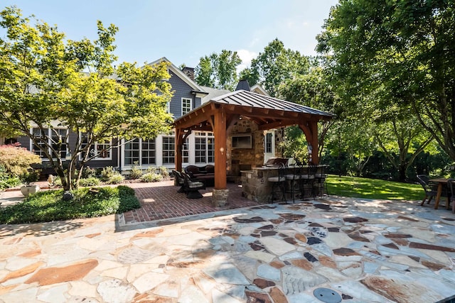 view of patio / terrace featuring a gazebo and exterior bar