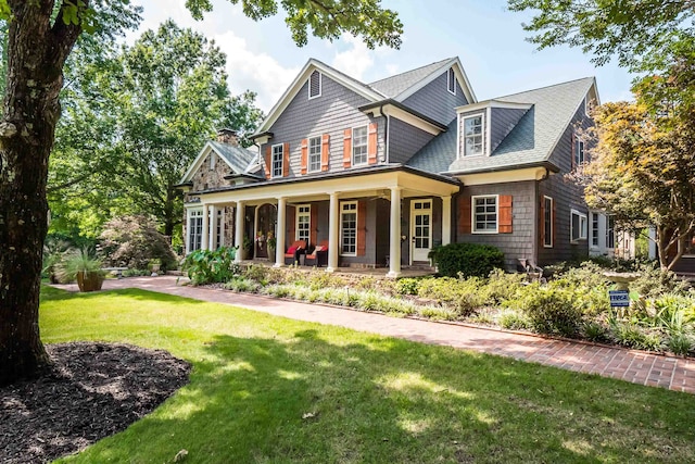 craftsman-style house featuring covered porch and a front lawn