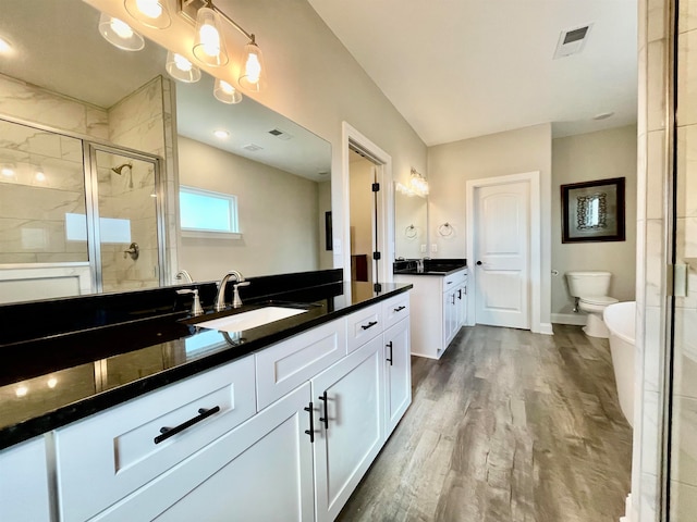 bathroom with toilet, vanity, an enclosed shower, and hardwood / wood-style flooring