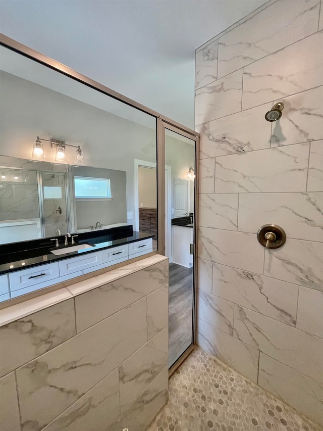 bathroom with a tile shower and sink