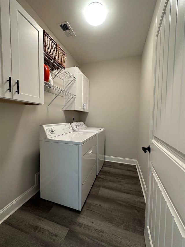 washroom featuring dark hardwood / wood-style floors, cabinets, and separate washer and dryer