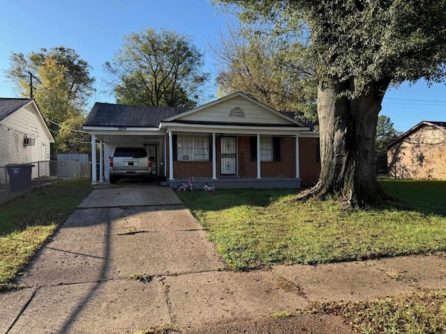 view of front of house featuring covered porch, a front yard, and a carport