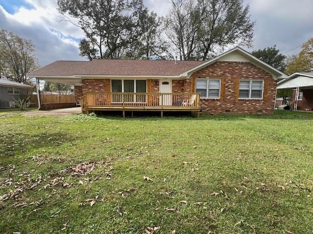 rear view of house featuring a wooden deck, crawl space, an attached carport, brick siding, and a yard
