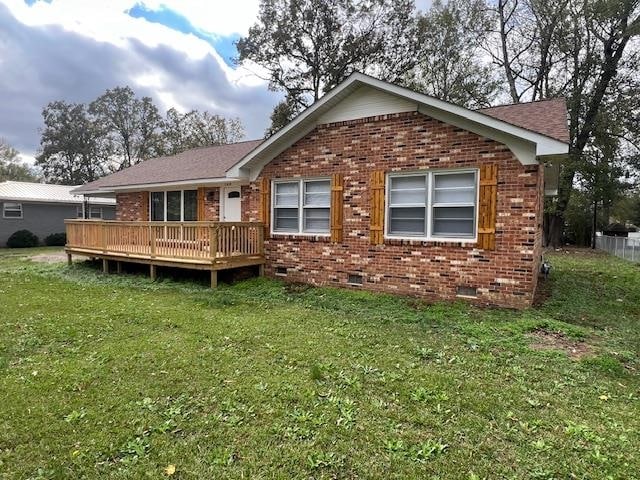 rear view of property with a lawn and a deck