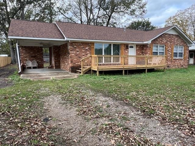 view of front of home with a wooden deck and a front lawn