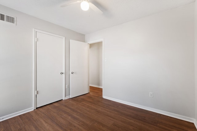 unfurnished bedroom with ceiling fan and dark hardwood / wood-style flooring