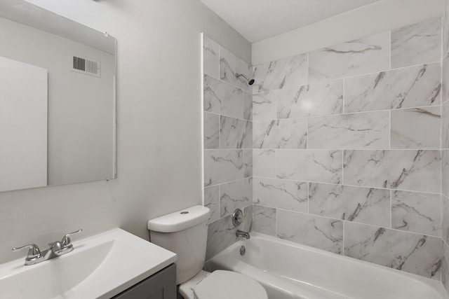 full bathroom featuring a textured ceiling, vanity, toilet, and tiled shower / bath