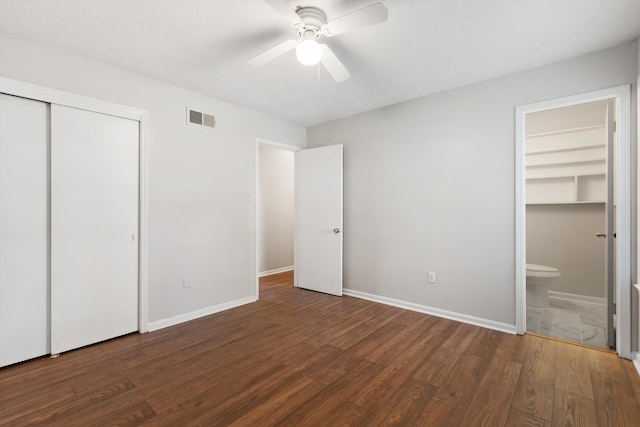 unfurnished bedroom with ceiling fan, dark hardwood / wood-style flooring, and ensuite bathroom