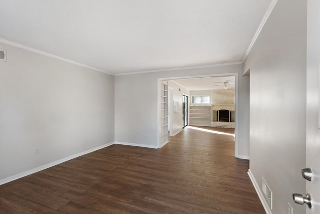 empty room with a fireplace, dark hardwood / wood-style floors, and ornamental molding