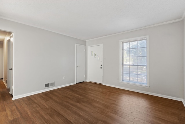 empty room with dark wood-type flooring, a textured ceiling, and ornamental molding