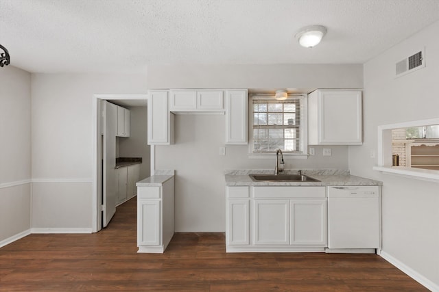 kitchen featuring sink, dark hardwood / wood-style floors, white dishwasher, a textured ceiling, and white cabinets