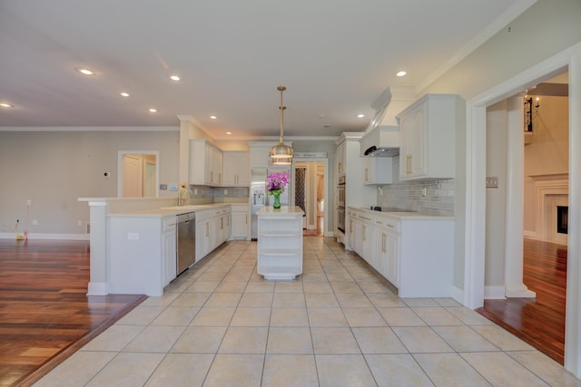 kitchen featuring stainless steel dishwasher, decorative backsplash, light wood-type flooring, a kitchen island, and kitchen peninsula