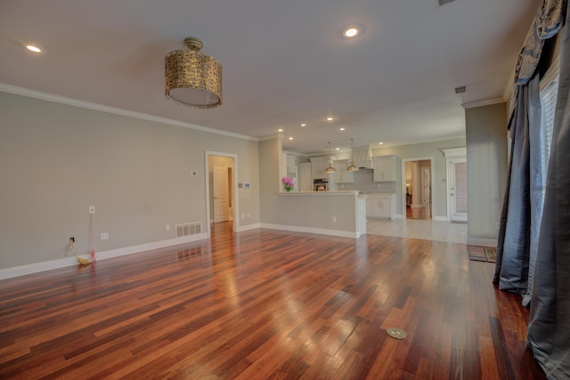 unfurnished living room featuring crown molding and dark wood-type flooring