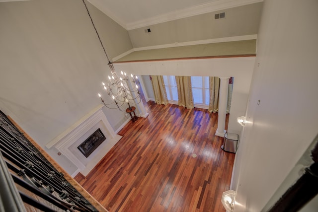 living room featuring a notable chandelier, ornamental molding, and dark wood-type flooring