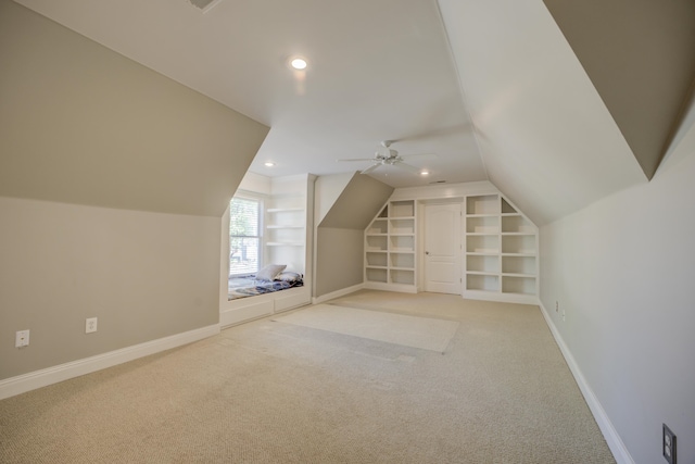 bonus room featuring carpet, ceiling fan, built in shelves, and vaulted ceiling