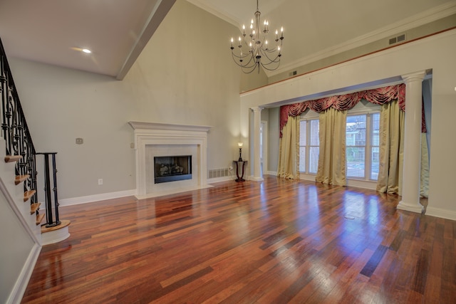 unfurnished living room featuring dark hardwood / wood-style flooring, crown molding, a high ceiling, and a chandelier