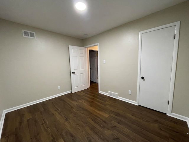 unfurnished bedroom with dark hardwood / wood-style floors