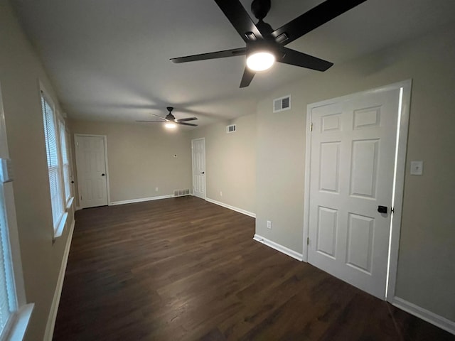 unfurnished room with ceiling fan and dark wood-type flooring