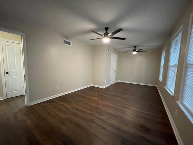 empty room with ceiling fan and dark hardwood / wood-style floors