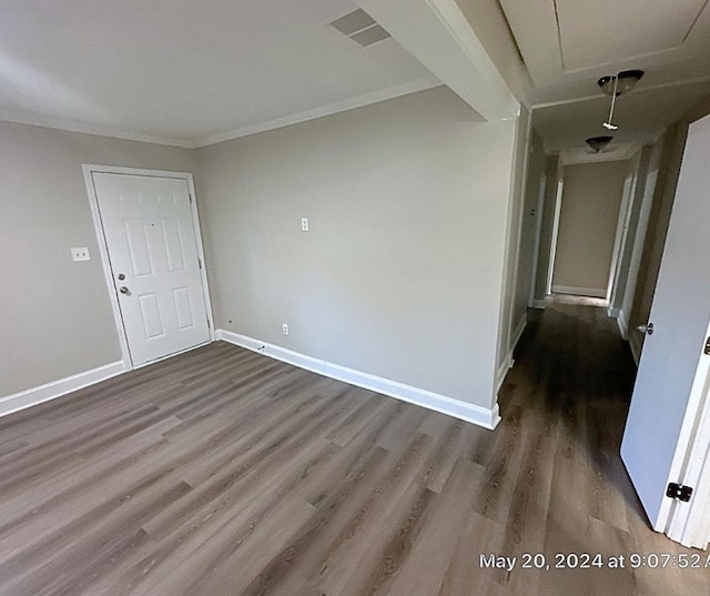 spare room with crown molding and dark hardwood / wood-style floors