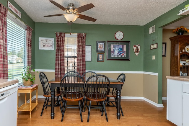 dining room featuring a textured ceiling, light hardwood / wood-style flooring, and ceiling fan