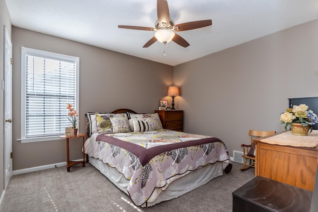 carpeted bedroom featuring a textured ceiling and ceiling fan