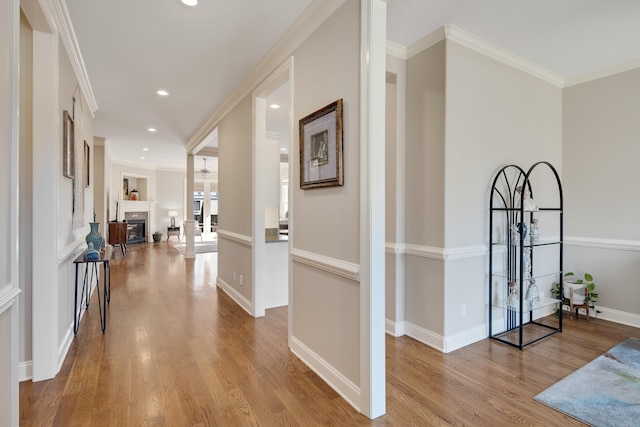 hallway featuring crown molding and light hardwood / wood-style flooring