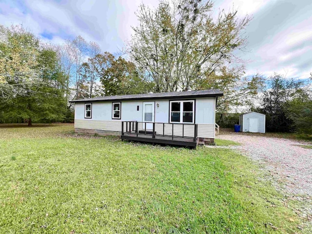 manufactured / mobile home featuring a front lawn, a deck, and a storage unit