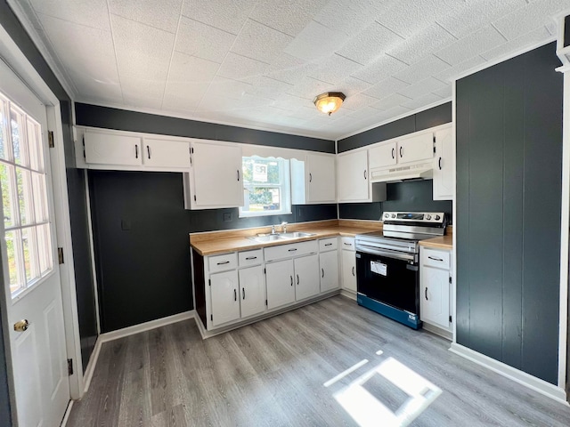 kitchen featuring white cabinets, electric stove, sink, and light hardwood / wood-style flooring