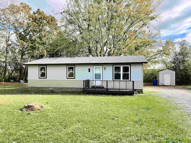 view of front of home with a shed and a front lawn