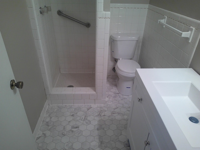 bathroom featuring a tile shower, tile patterned flooring, tile walls, and toilet