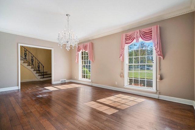 unfurnished room featuring crown molding, dark wood-type flooring, and an inviting chandelier