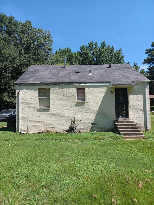 rear view of property featuring a lawn