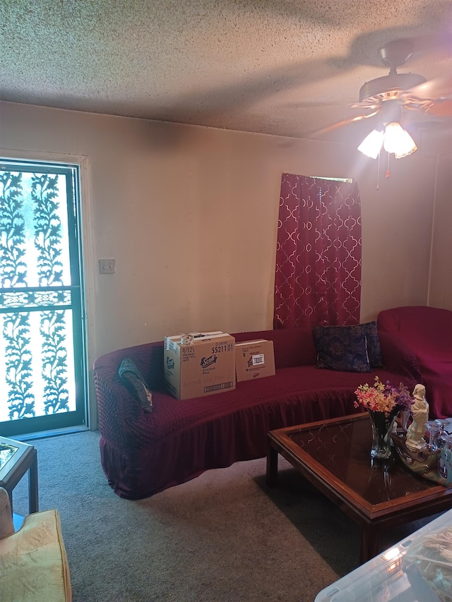 carpeted living room with ceiling fan and a textured ceiling