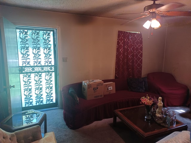 carpeted living room with a textured ceiling and ceiling fan